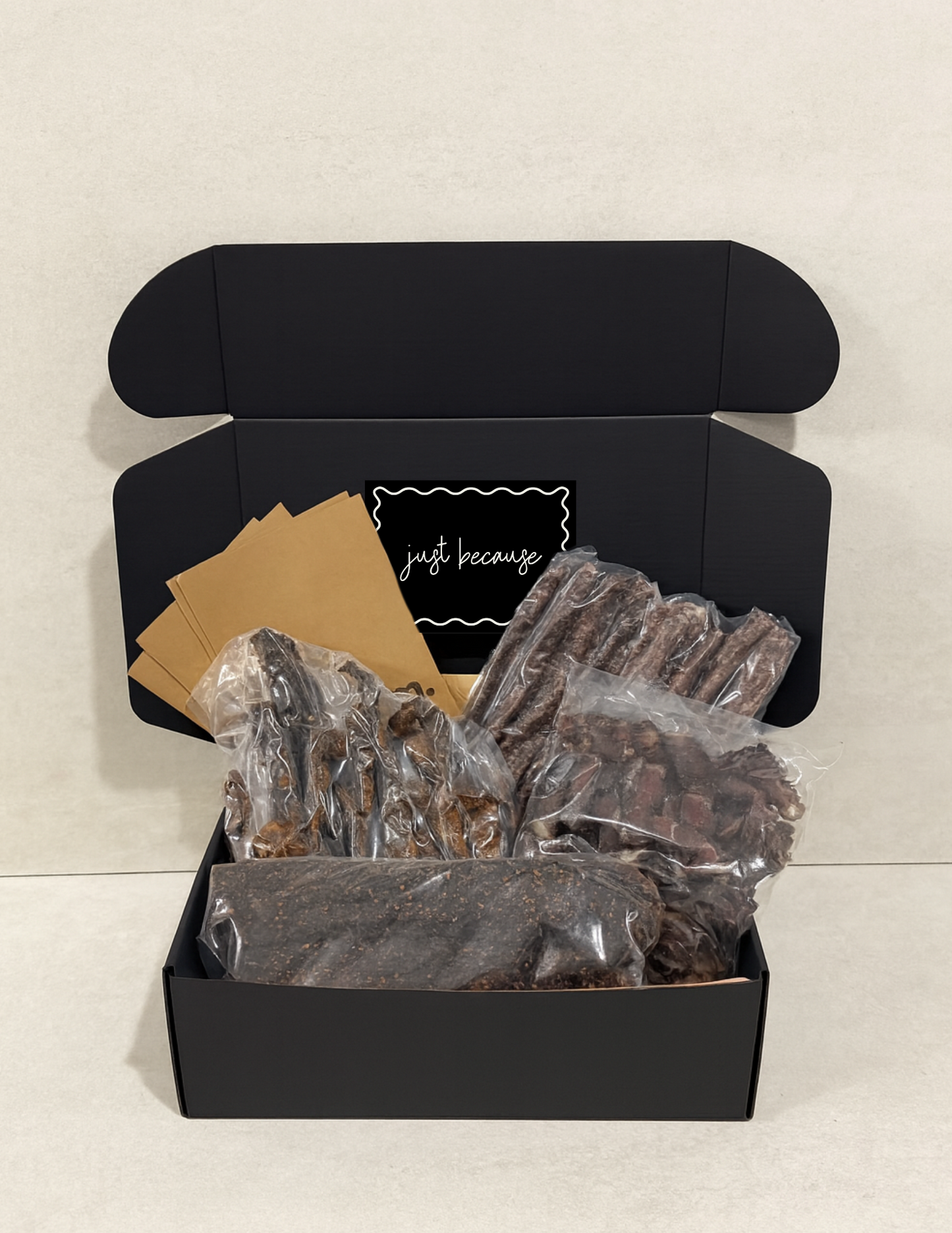 Black gift box with biltong and droewors inside, with a just because sticker